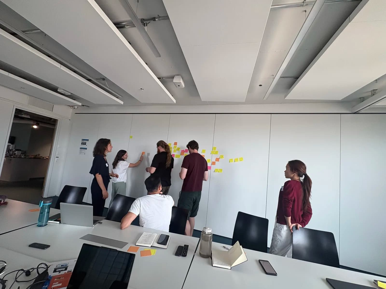 Participants clustering sticky notes on a wall during the working-group session
